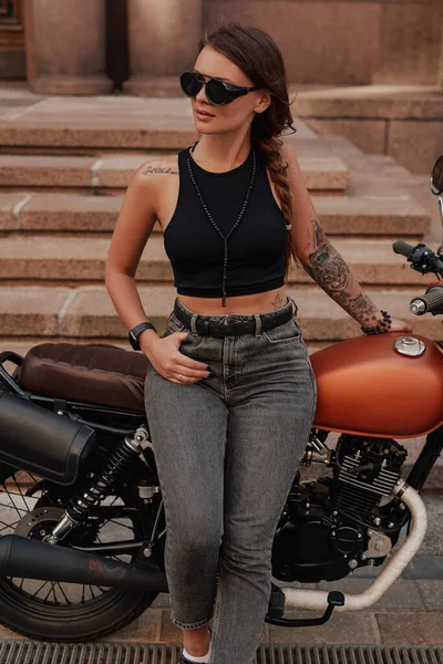 Стильная женщина в темной одежде с ретро-велосипедом — стоковое фото