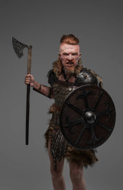 Kızıl saçlı çılgın Viking kalkan ve balta ile Gri üzerinde izole