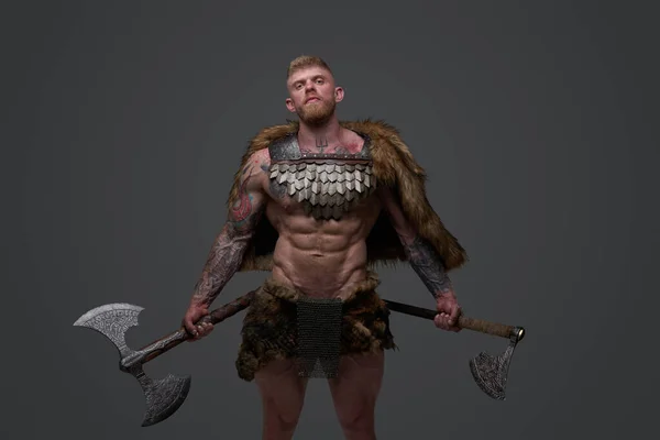 Proud viking dressed in fur and armor holding two axes — Stock Photo, Image