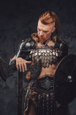 Viking karanlık arka planda kalkan ve baltayla poz veriyor