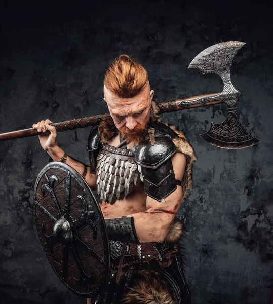Öfkeli kızıl saçlı Viking omzunda baltayla aşağıya bakıyor. — Stok fotoğraf