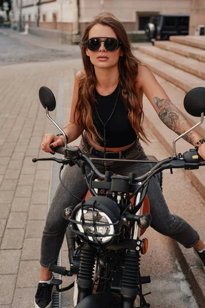 Buscando mujer elegante posando en bicicleta oscura clásica al aire libre —  Fotos de Stock