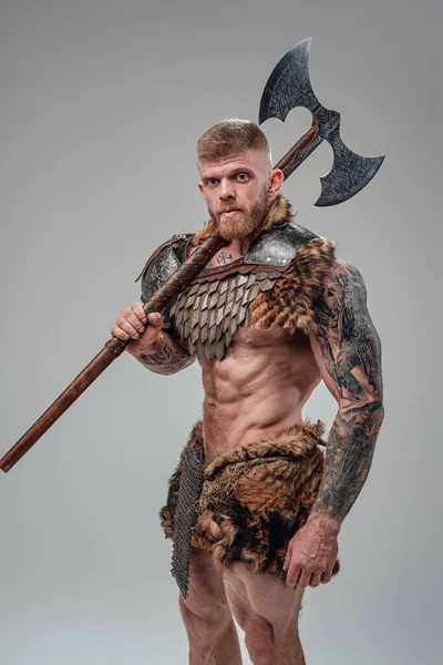 Formidable vikingo con cuerpo fuerte sosteniendo hacha de dos manos — Foto de Stock