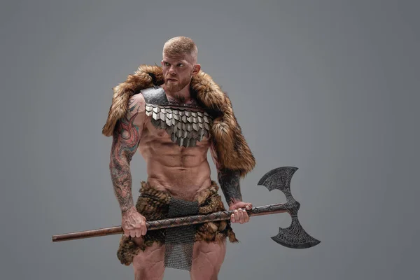 Vikingo fuerte con hacha y torso desnudo sobre fondo gris — Foto de Stock