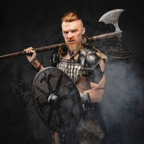 Kalkanları ve baltaları duman içinde duran vahşi Viking.