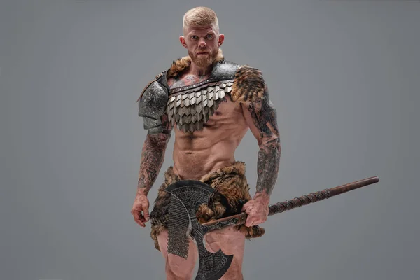 Bonito guerreiro do norte segurando machado contra fundo cinza — Fotografia de Stock
