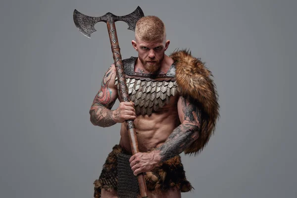 Tetovaný svalnatý Viking držící na rameni dvouruční sekeru — Stock fotografie