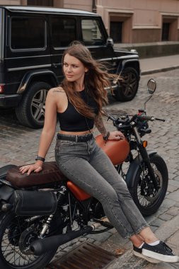 Dövmeli güzellik arka sokakta eski stil bisiklette oturuyor.