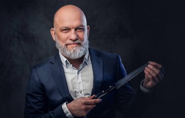 Esmer arka planda bıçaklı modaya uygun yaşlı bir aşçı.