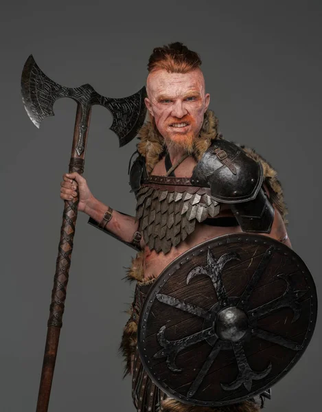 Barbaric viking warrior wielding axe and shield isolated on gray — Stock Photo, Image