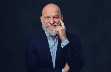 Neşeli ve kel büyükbaba karanlık arka planda poz veriyor