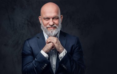 Neşeli ve kel büyükbaba karanlık arka planda poz veriyor