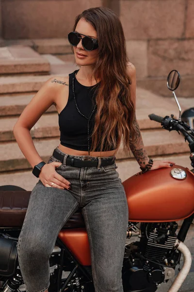 Привлекательный женский хипстер и мотоцикл в стиле ретро на открытом воздухе — стоковое фото