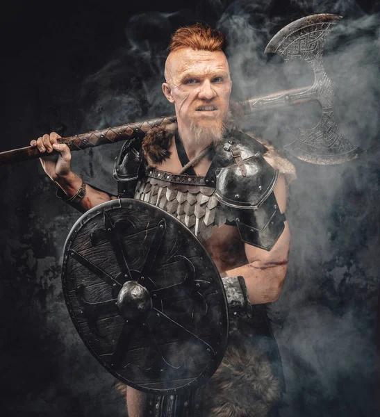Violent viking with shield and axe posing in smoke — Stock Photo, Image