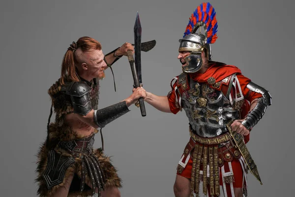 Viking warrior assaults roman centurion against gray background — Stock Photo, Image