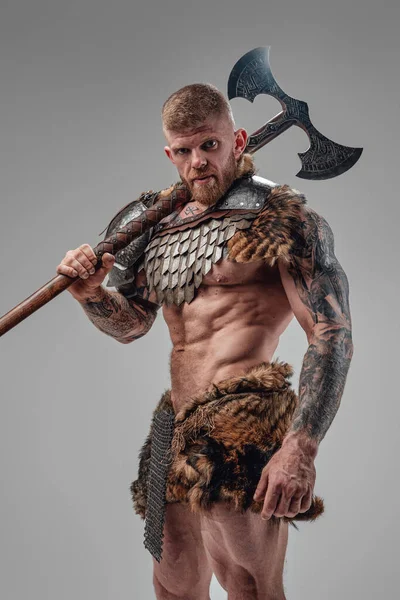 Formidable vikingo con cuerpo fuerte sosteniendo hacha de dos manos — Foto de Stock