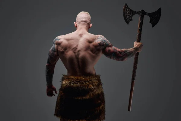 Tattooed viking with steel axe his back facing to camera — Stock Photo, Image