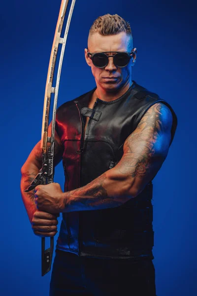 사이버 펑크 스타일에 푸른 배경에 검을 대는 근육질의 남자 — 스톡 사진