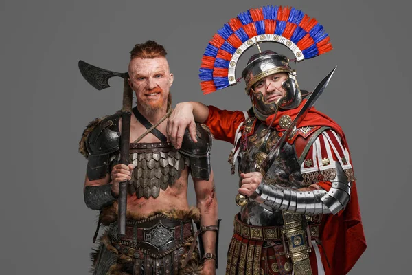 Χαρούμενος Βίκινγκ και Ρωμαίος στρατιώτης ποζάροντας σε γκρίζο φόντο — Φωτογραφία Αρχείου