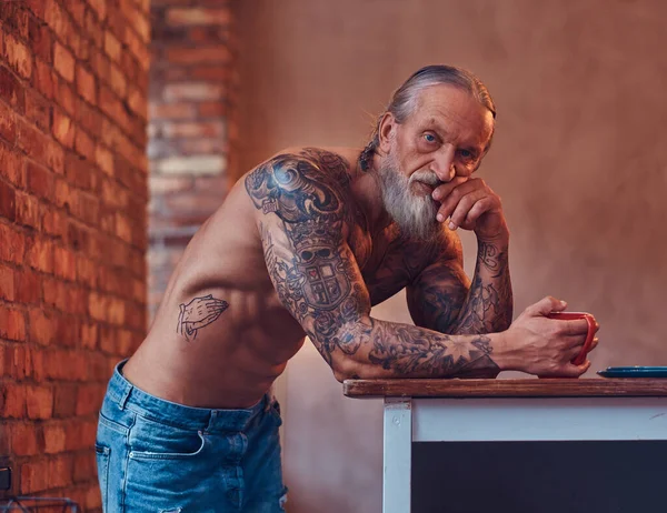 Homem idoso muscular com corpo tatuado dentro da sala — Fotografia de Stock