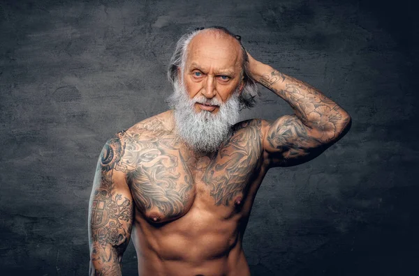 Homme âgé musculaire avec corps tatoué sur fond sombre — Photo