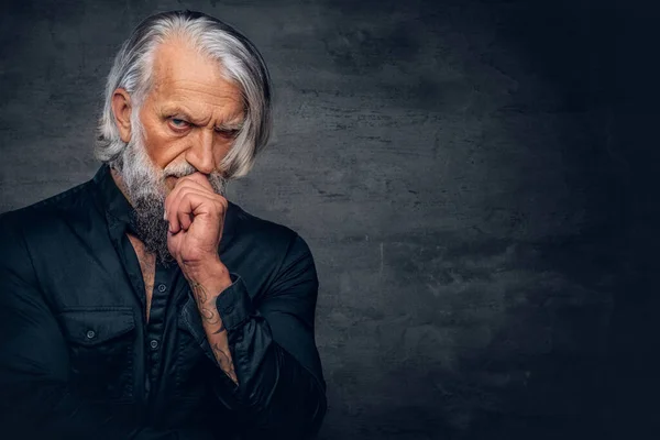 Pensive oude man met lange baard poseren tegen donkere achtergrond — Stockfoto