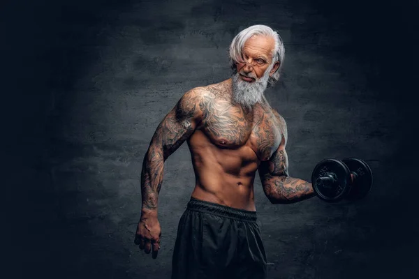 Baard oude man bodybuilder met tatoeages houden halter — Stockfoto