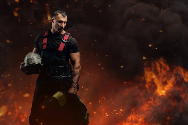 Bátor tűzoltó, aki kemény kalapban tartja védőruháját. — Stock Fotó