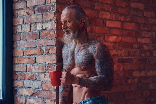 Homem idoso muscular com corpo tatuado com xícara de café — Fotografia de Stock