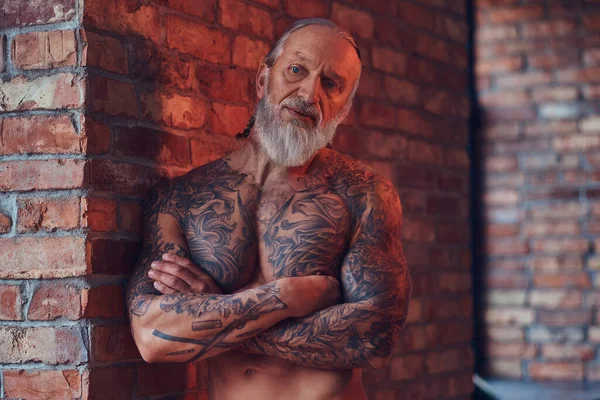 Muskularny starzec z wytatuowanym ciałem w pomieszczeniu — Zdjęcie stockowe