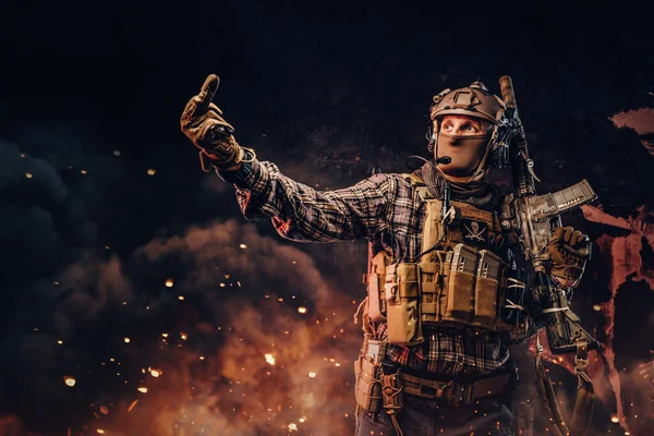 Speciální voják se střelnou zbraní ukazující prostředníček — Stock fotografie