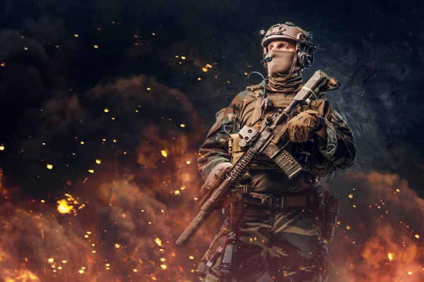 Militär soldat klädd i uniform med gevär mot eld — Stockfoto