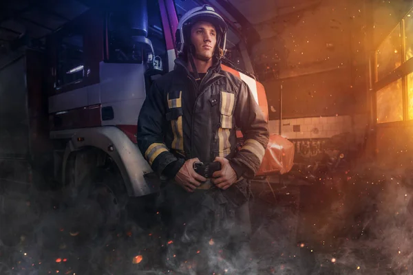 Pyšný hasič pózující kolem požární vůz vnitřní požární stanice — Stock fotografie