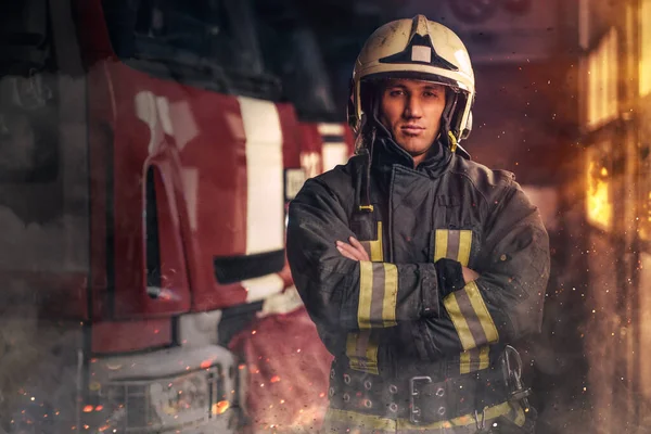 Brave fireman posing around fire truck indoors fire station