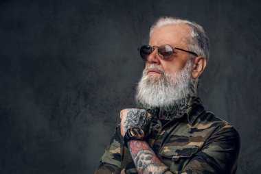 Güneş gözlüklü şık büyükbaba ve karanlık arka planda çapraz kollar