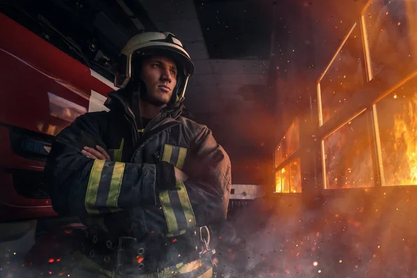 Zelfverzekerde brandweerman gekleed in beschermende werkkleding met gekruiste armen — Stockfoto