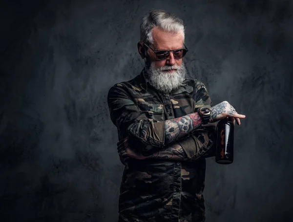 Cool vieil homme avec de la bière posant sur fond sombre — Photo