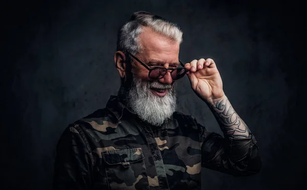 Радісний старий з татуюваннями одягнений у камуфляжний одяг — стокове фото