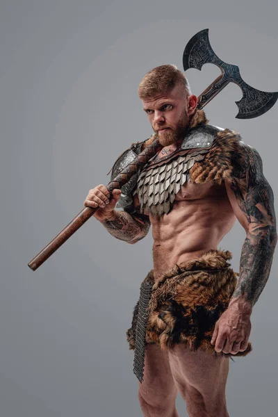 Formidable viking with strong body holding two handed axe