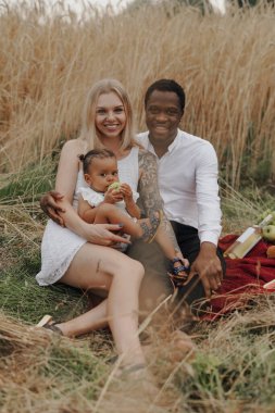 Kızı anne ve babasıyla piknik yapıyor.