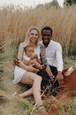 Kızı anne ve babasıyla piknik yapıyor.