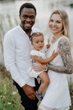 Kameraya bakarak birlikte poz veren mutlu çoklu etnik aile.