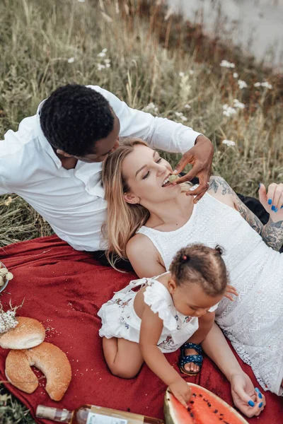 Multiracialt par som har picknick utomhus med sin dotter — Stockfoto