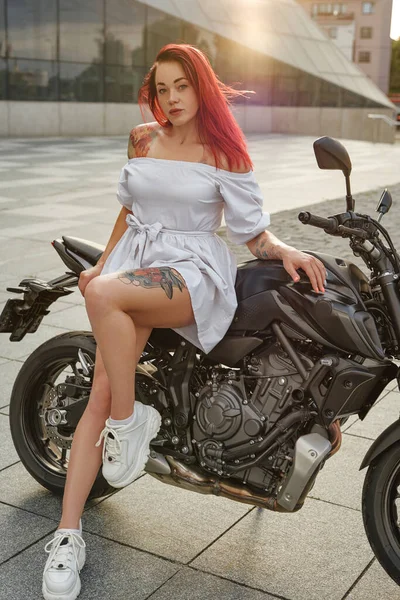 흰옷을 입은 빨간 머리의 여자 자전거타는 사람 이 거리에서 — 스톡 사진