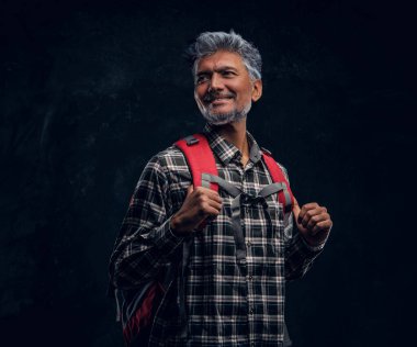 Kırmızı sırt çantalı yaşlı turistin portresi.