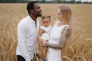 Çoklu etnik aile buğday tarlalarında birlikte eğleniyor.