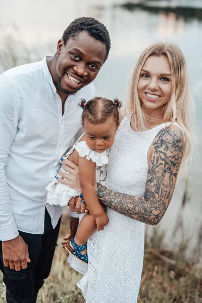 Kameraya bakarak birlikte poz veren mutlu çoklu etnik aile.