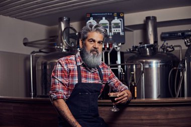 Bira fabrikasında bira bardağıyla bira üreticisi.