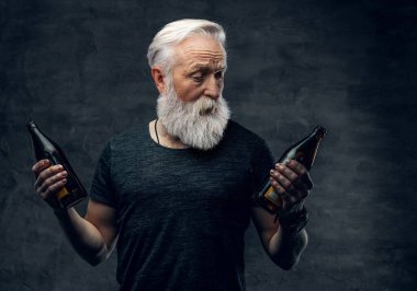 Uzun sakallı büyükbaba elinde iki şişe siyah arka plan tutuyor.