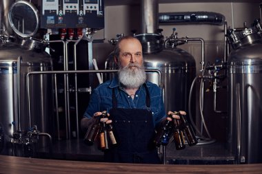 Çelik varillerin etrafına dövmeli yaşlı bir adam.